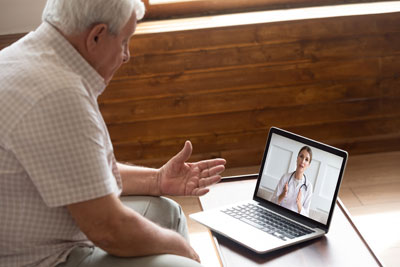 Man using computer for telehealth session.